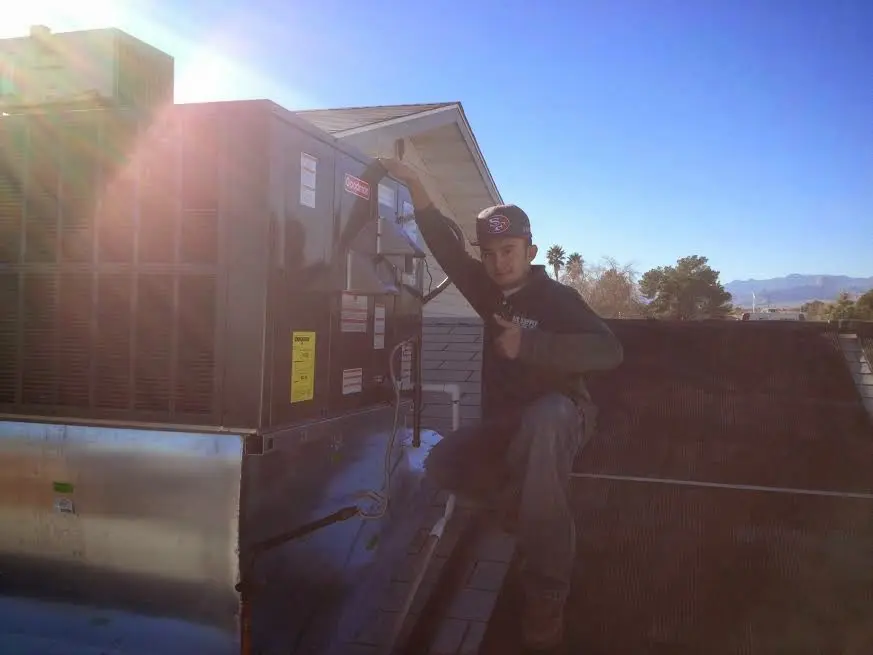 HVAC technician performing HVAC Inspection on a rooftop unit in Dixon